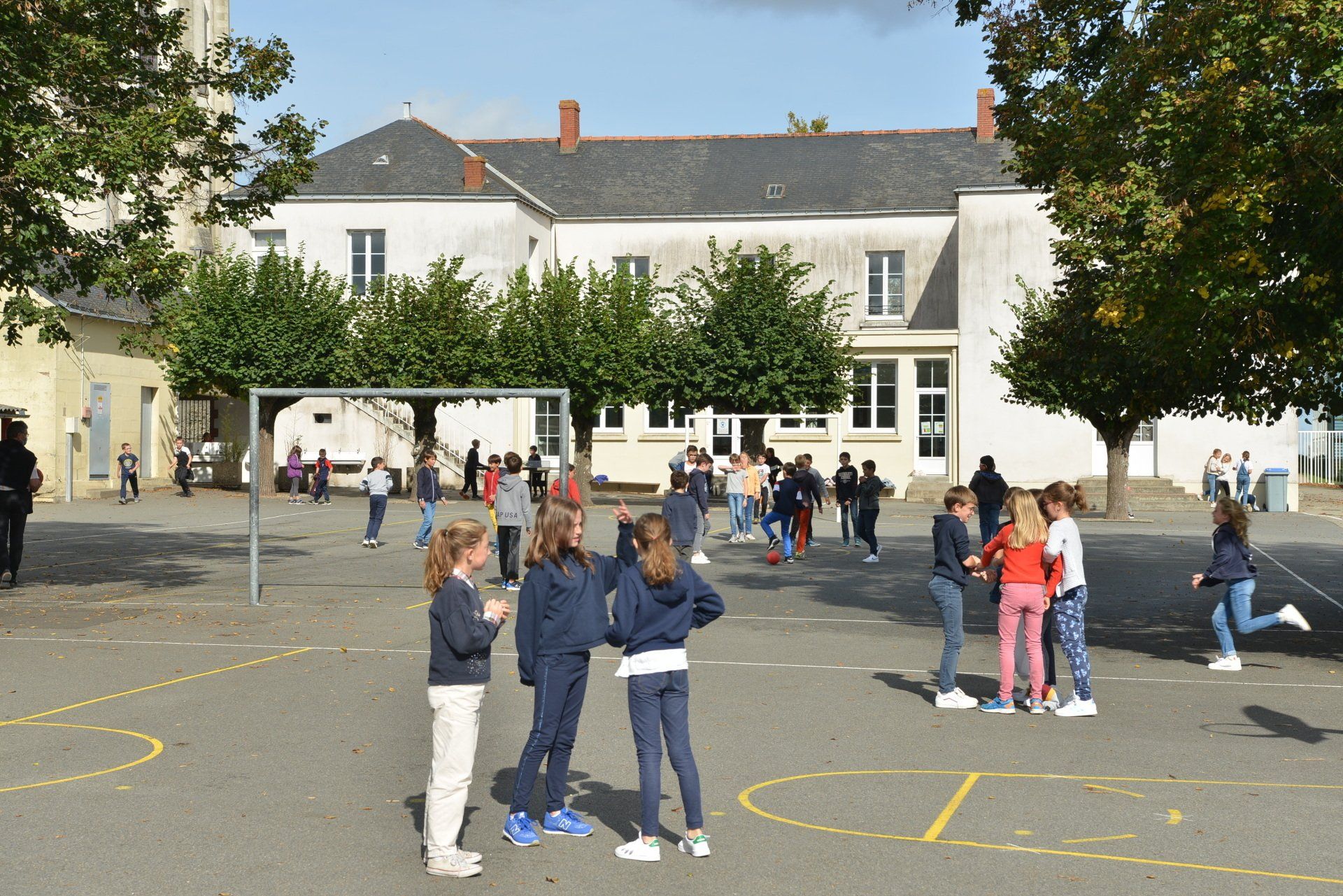 Cour d’école avec plusieurs élèves jouant et discutant
