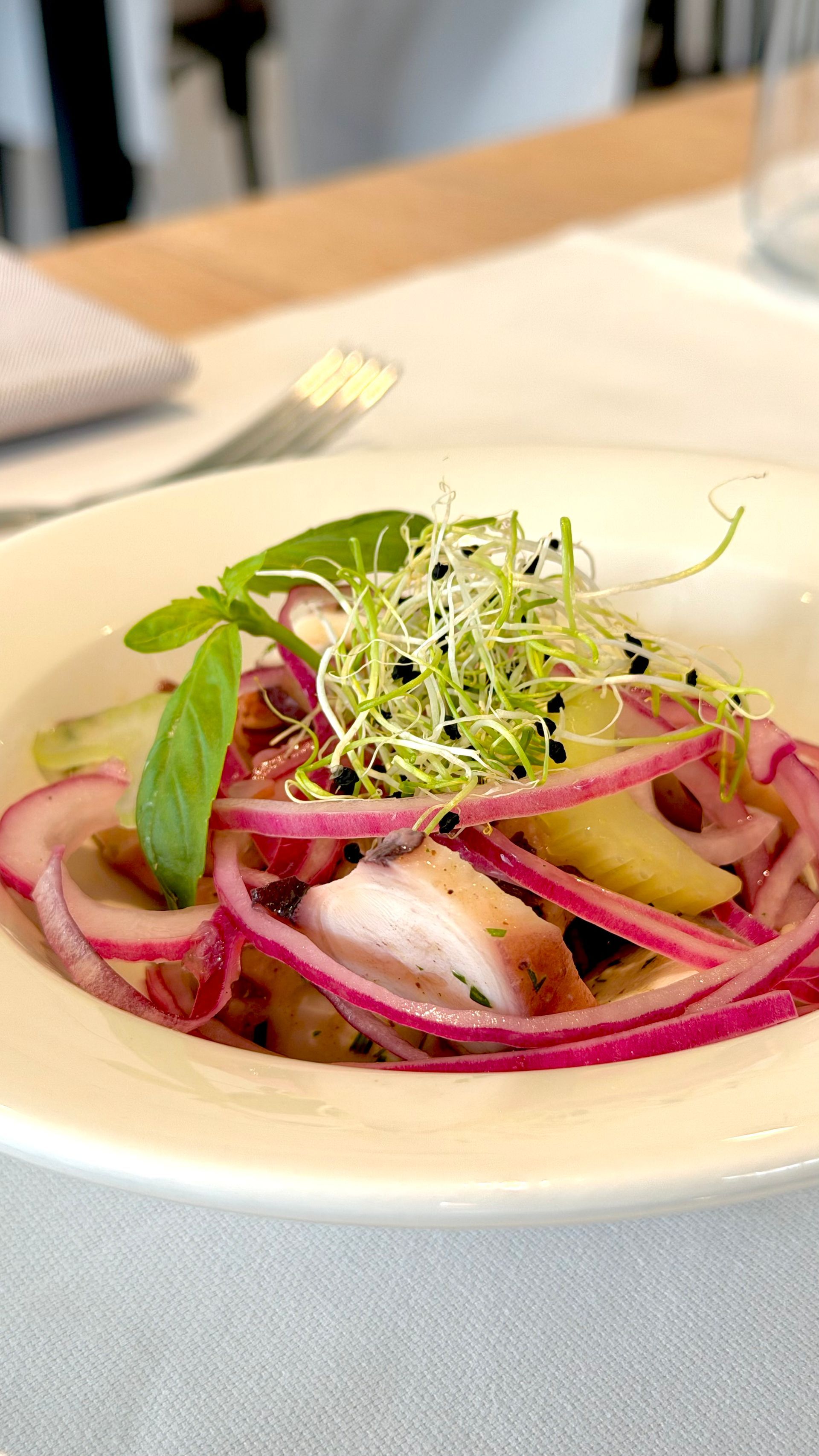In un ambiente luminoso e moderno, le persone brindano con calici di vino rosato attorno a un tavolo.