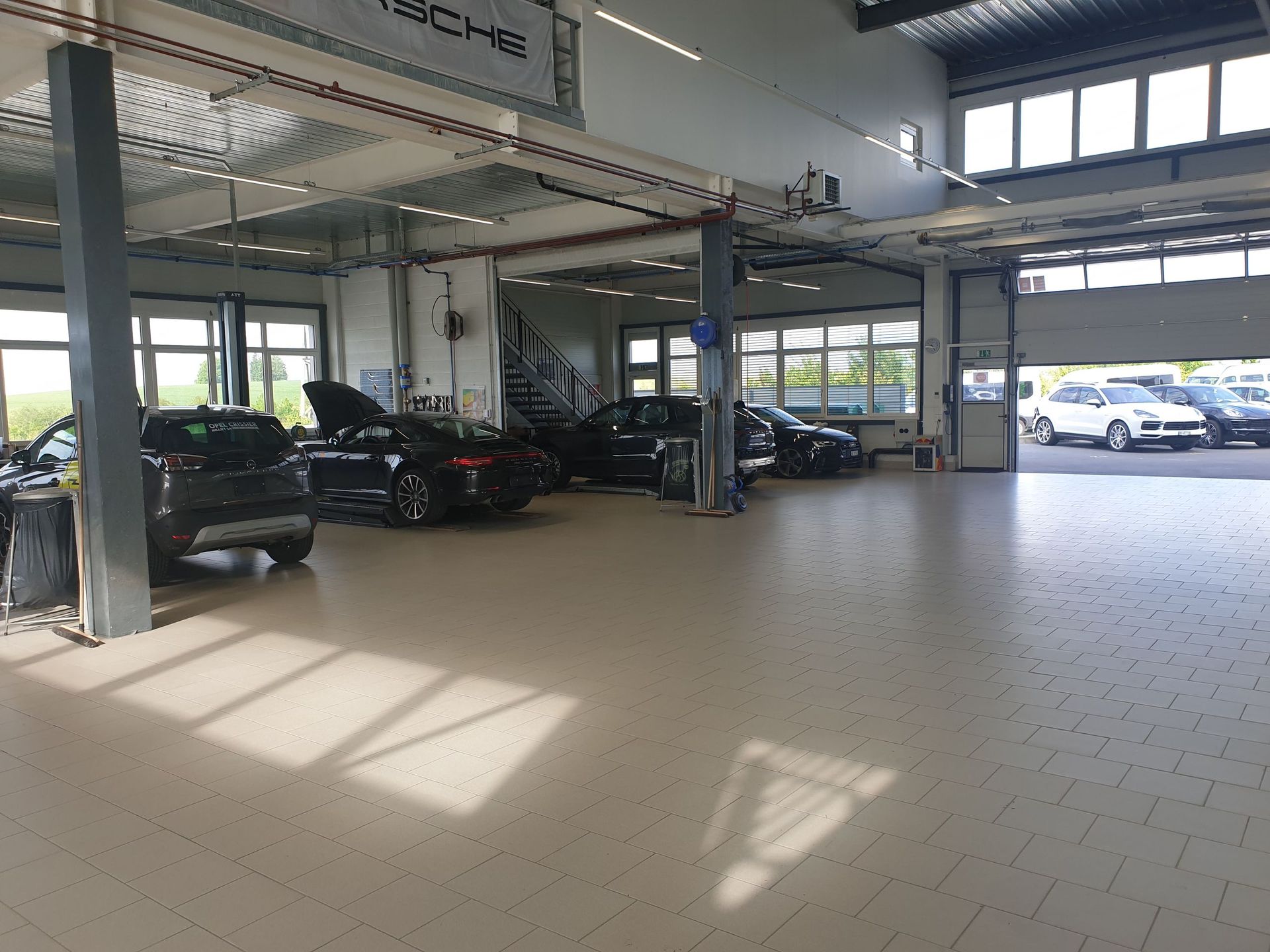 Une rangée de voitures est garée dans un grand garage