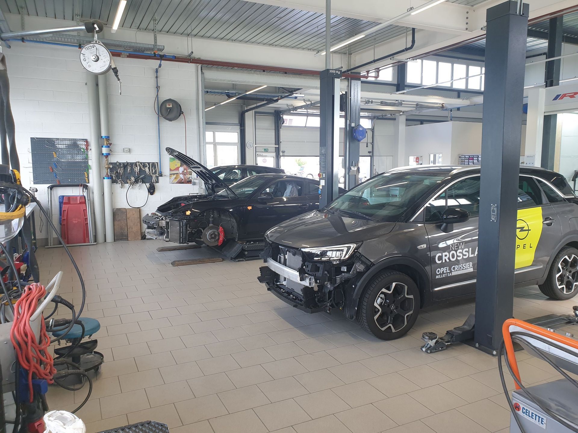 Une rangée de voitures est assise sur un ascenseur dans un garage.