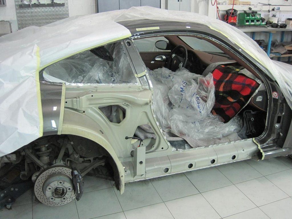 Une voiture qui a été emballée dans du plastique posée sur un sol carrelé