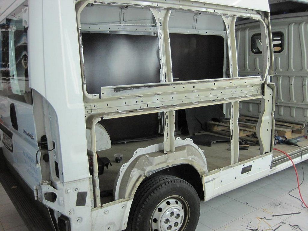 Une camionnette blanche est en cours de rénovation avec les lettres cb sur le côté