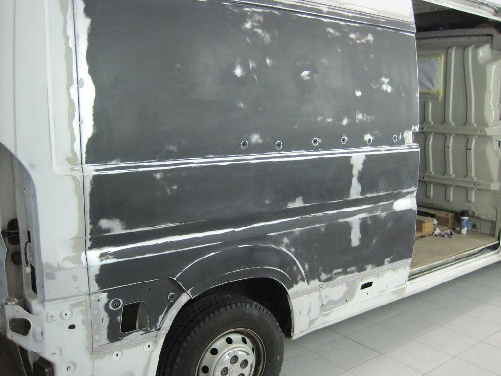 Une camionnette blanche est en train d'être peinte dans un garage