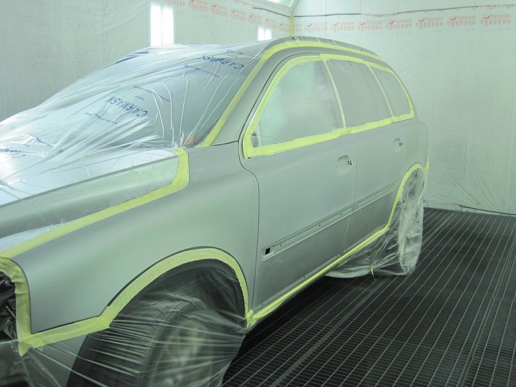 Une voiture est en train d'être peinte dans une cabine de peinture