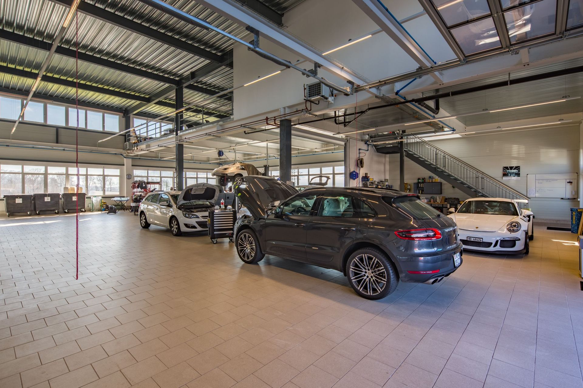 Une rangée de voitures est garée dans une grande salle d'exposition.