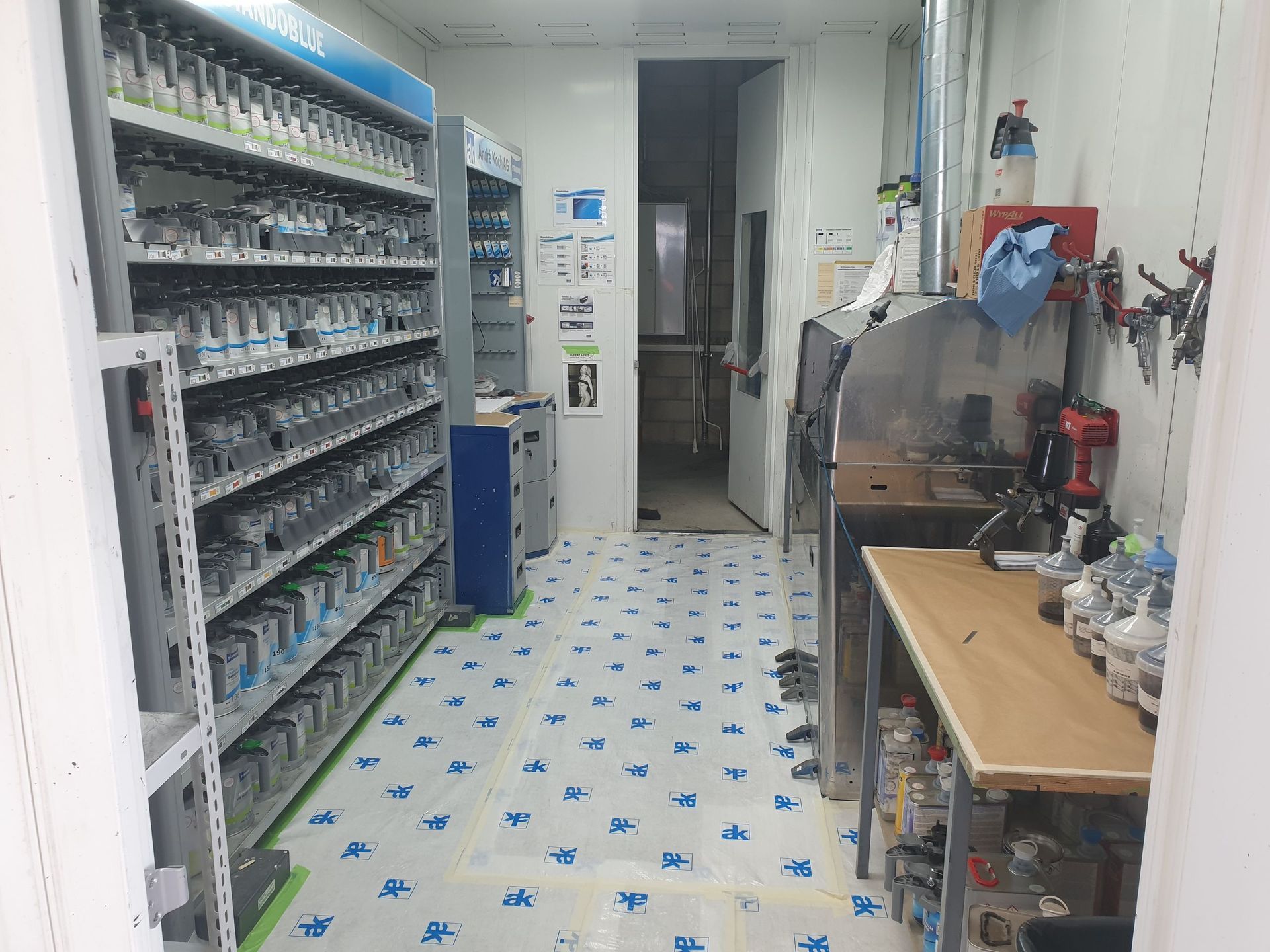 Une pièce avec beaucoup d'étagères et une table dedans.