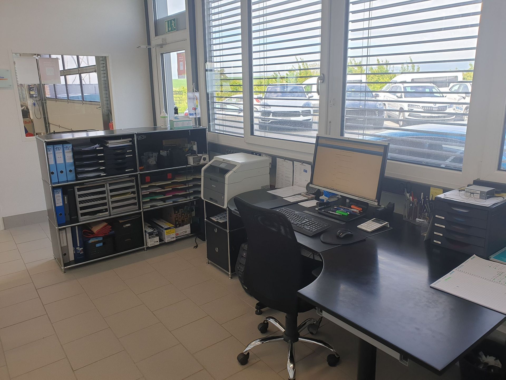 Un bureau avec deux ordinateurs et une imprimante dans un bureau