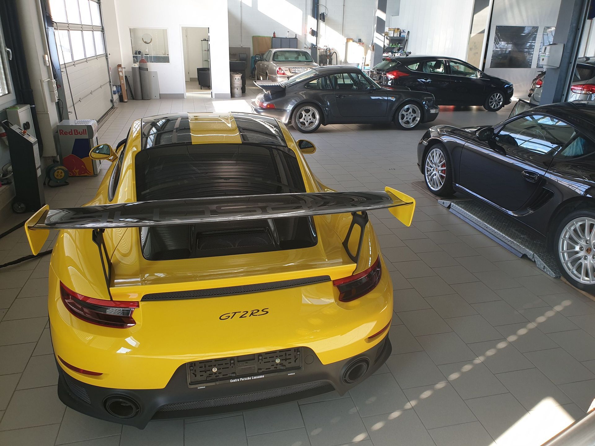 Une Porsche 911 GT2 RS jaune est garée dans un garage.