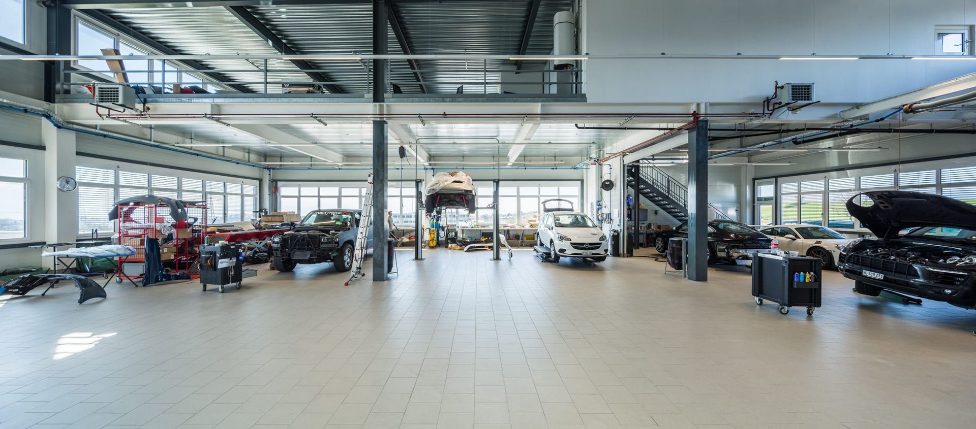 Un grand garage rempli de voitures en travaux.