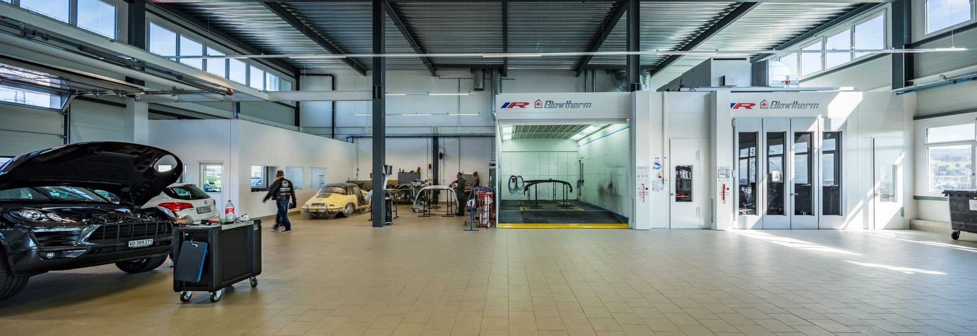 Une voiture est en cours de réparation dans un garage.