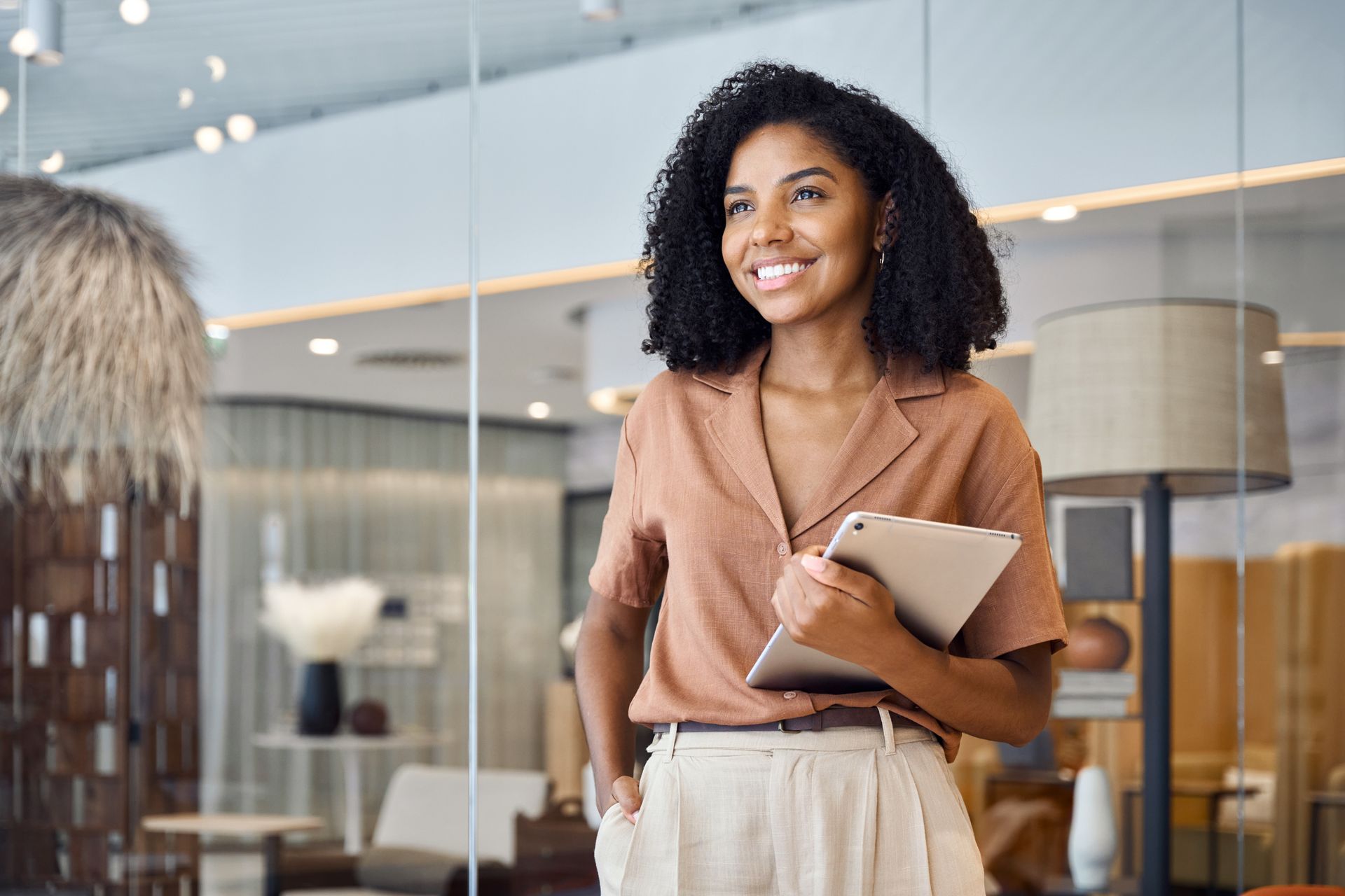 Femme souriante tenant un carnet dans un salon d'affaires moderne