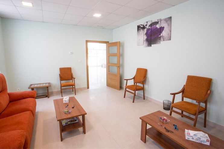 Una sala de estar con un sofá, sillas y una mesa de café.