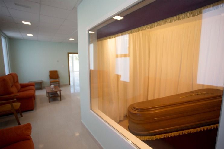 Una habitación con un ataúd dentro y una ventana.