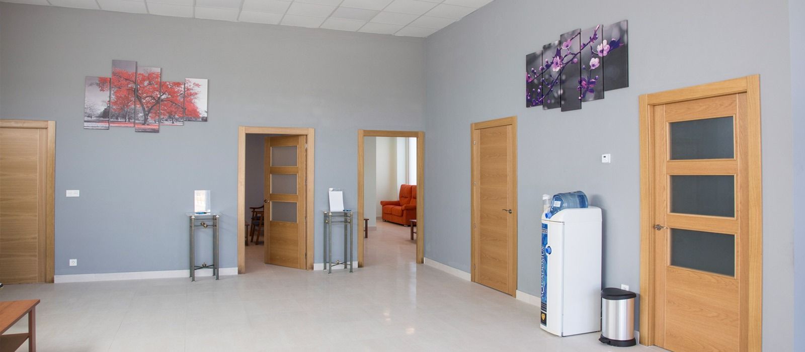 Una habitación grande con muchas puertas y un bote de basura.