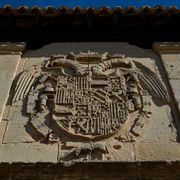Una talla de piedra de un escudo de armas en el costado de un edificio.
