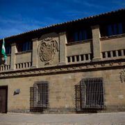 Un gran edificio con un escudo de armas en el costado.