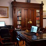 Un escritorio con una computadora portátil encima en una habitación con una estantería.