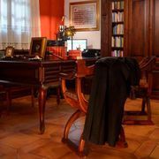 Hay una silla con una chaqueta encima en una habitación con un escritorio y sillas.