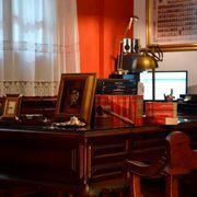 Hay un escritorio con una lámpara y una computadora encima.