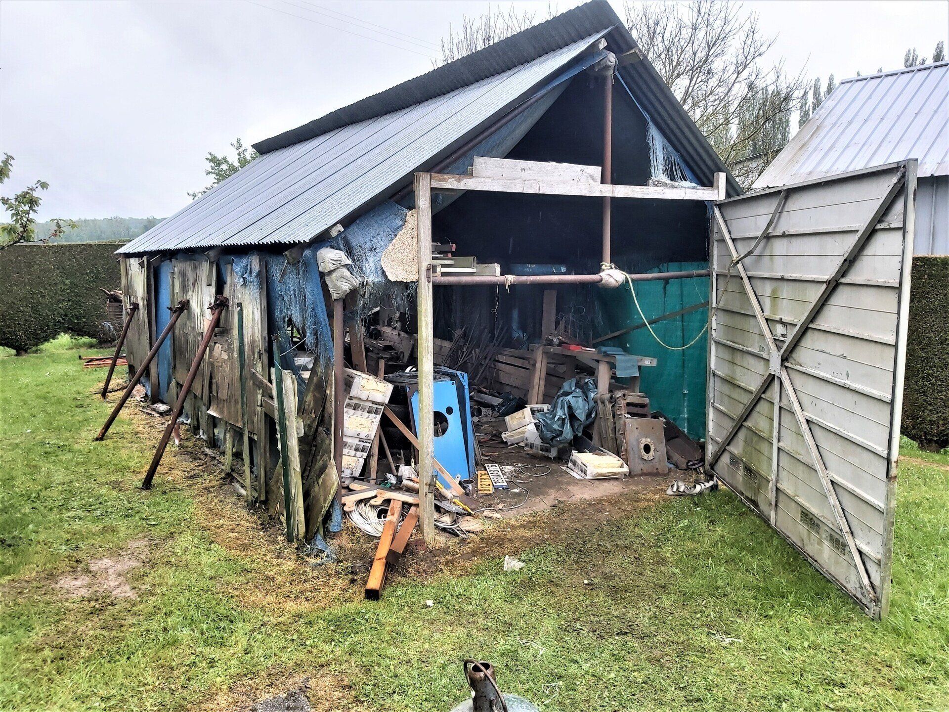 Un atelier de type hangar en mauvais état et encombré.