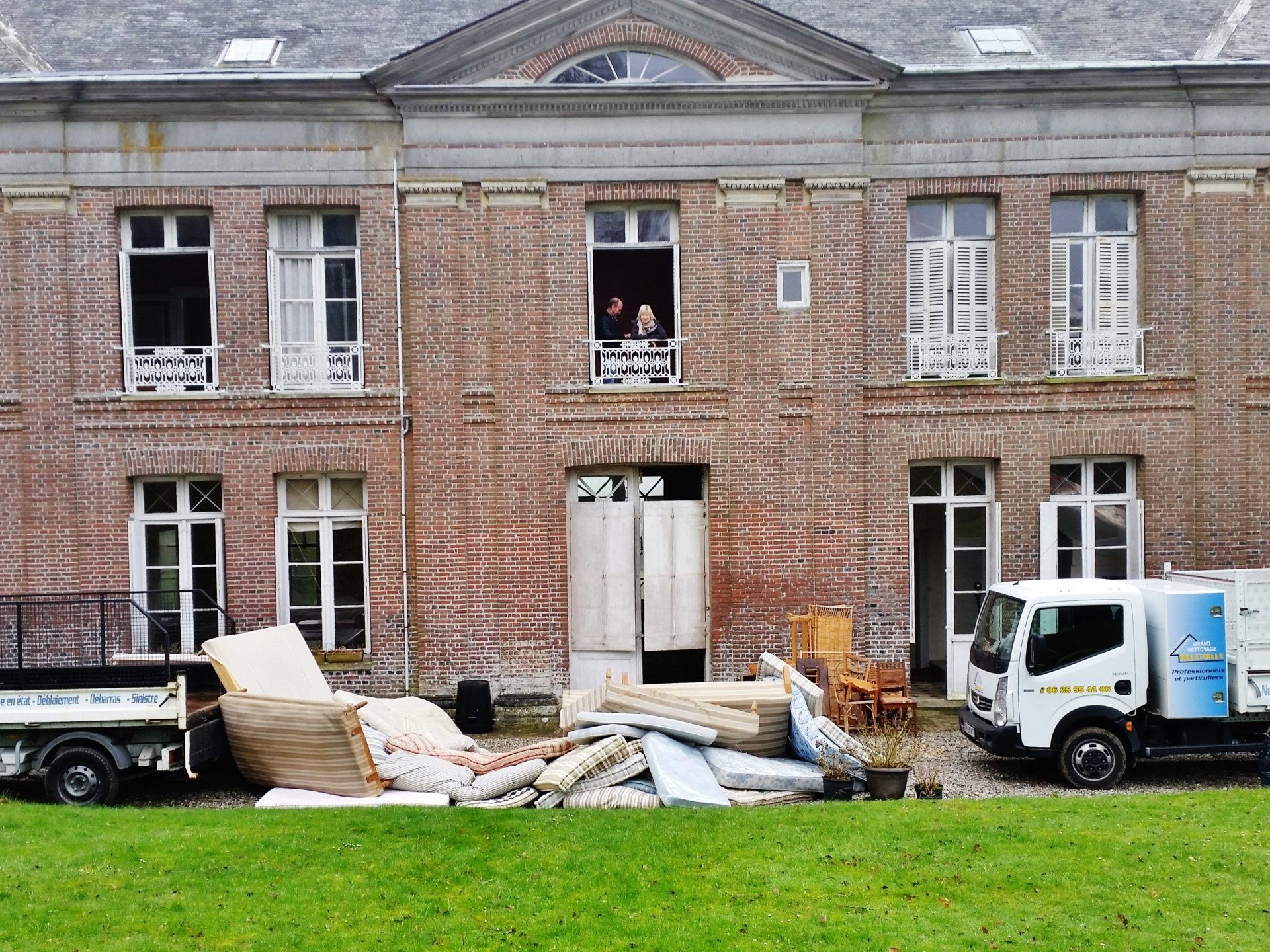 Un tas de matelas entre 2 camions au pied d'une maison.