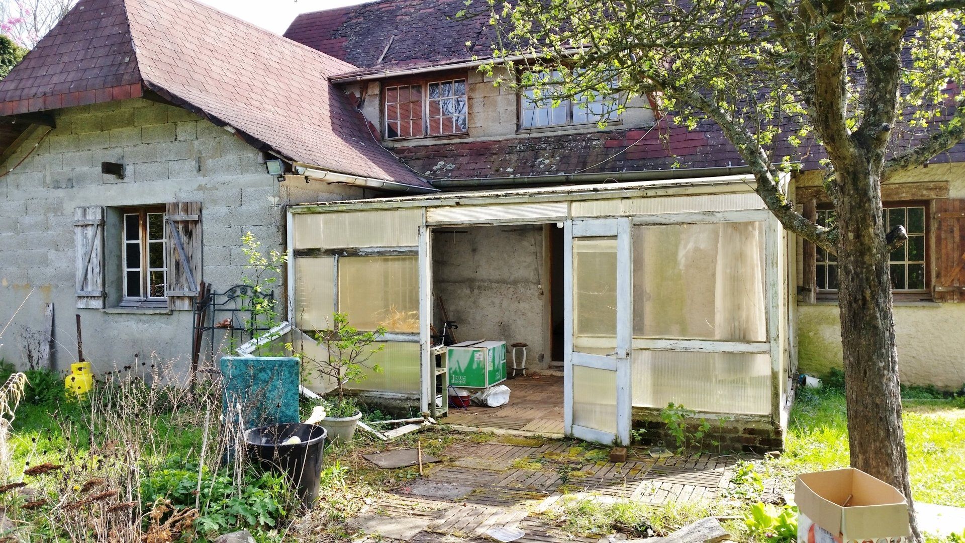Une maison normande avec un vieux cabanon devant.