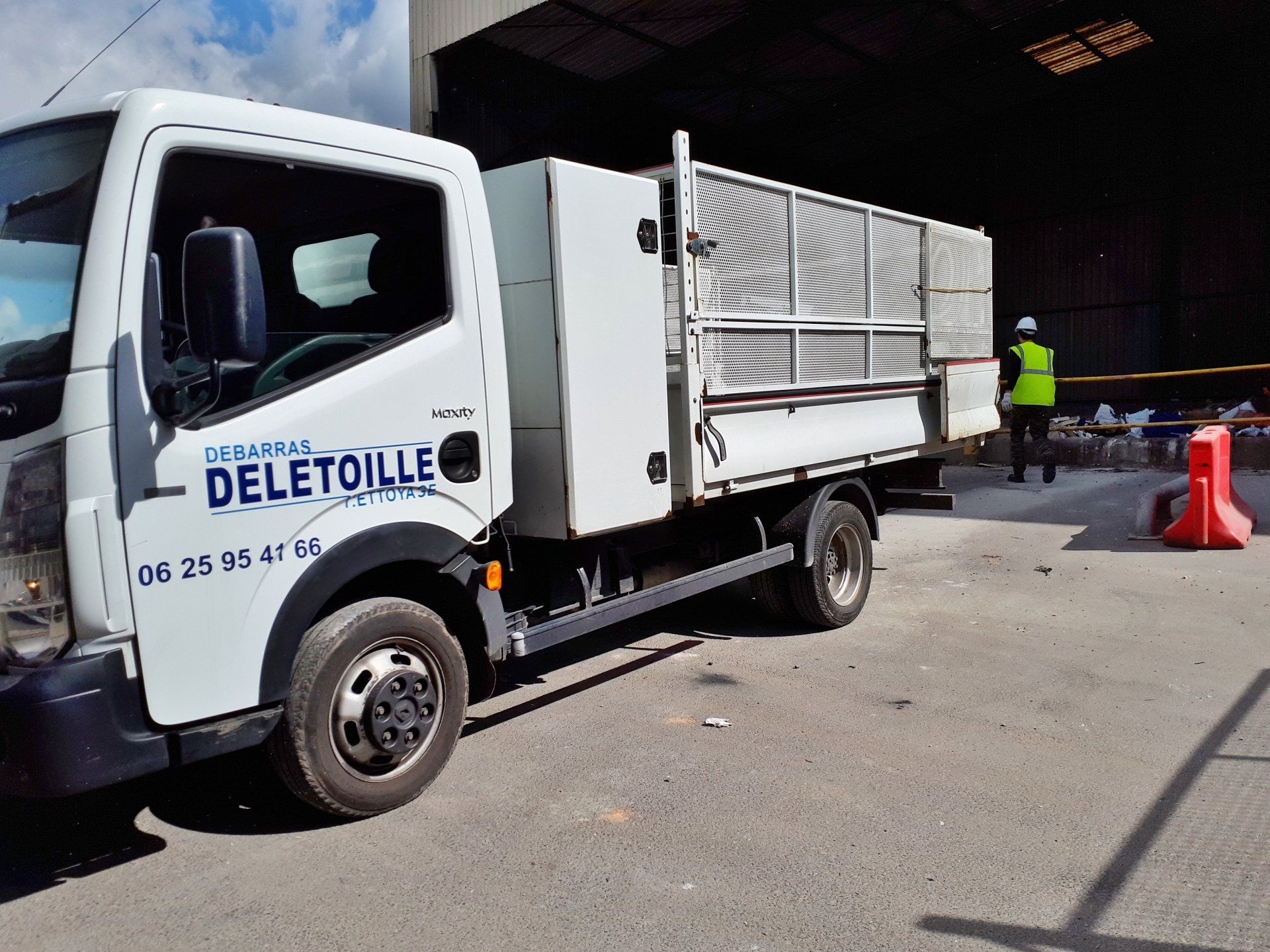 Un camion-benne de l'entreprise vu de côté.