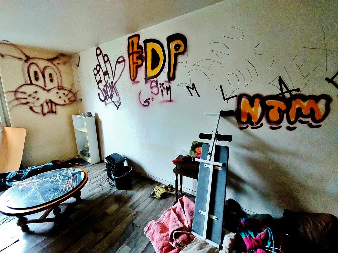 Une pièce encombrée dont les murs sont couverts de graffitis.