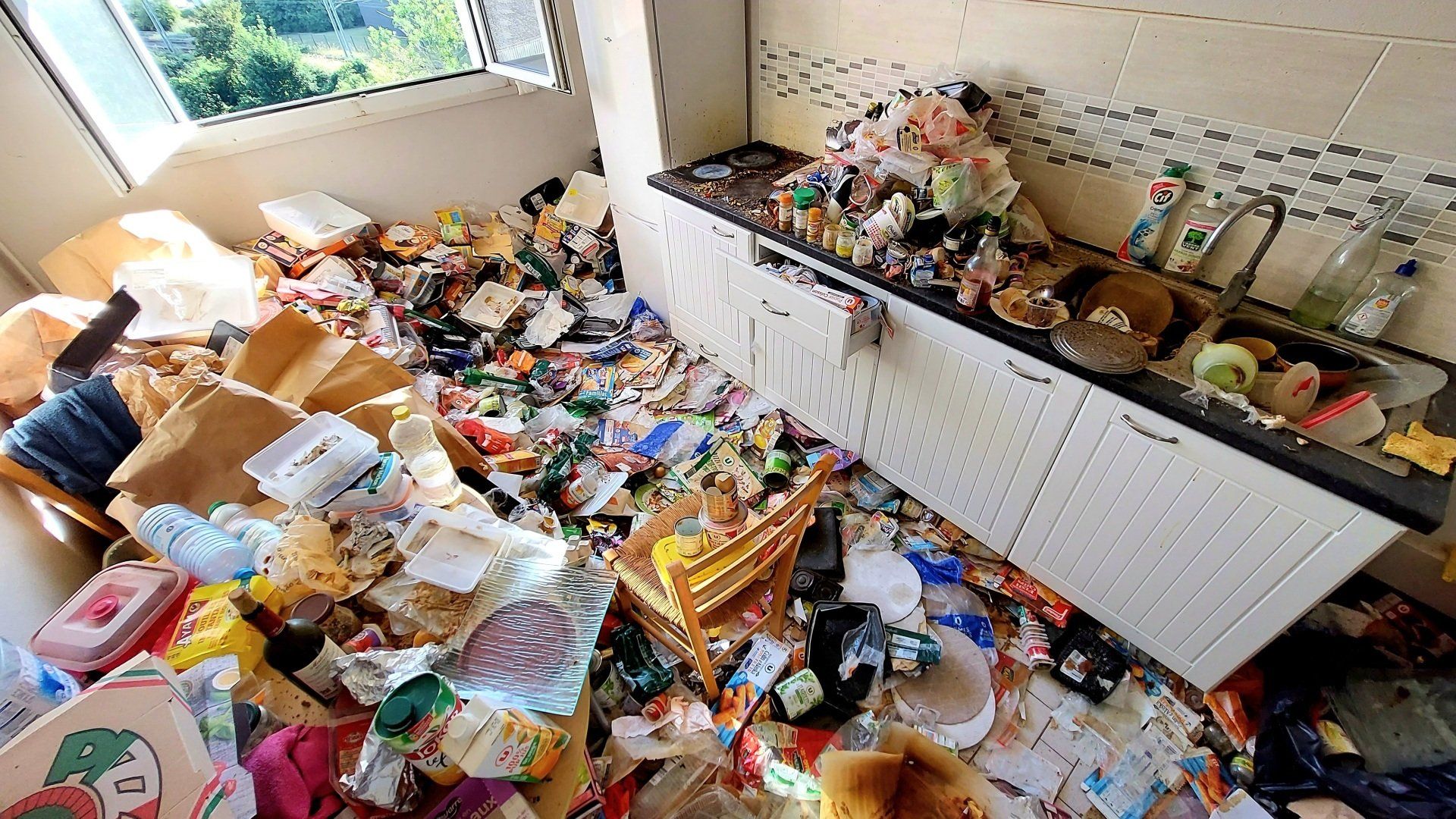 Une grande cuisine dont le sol est recouvert de déchets.