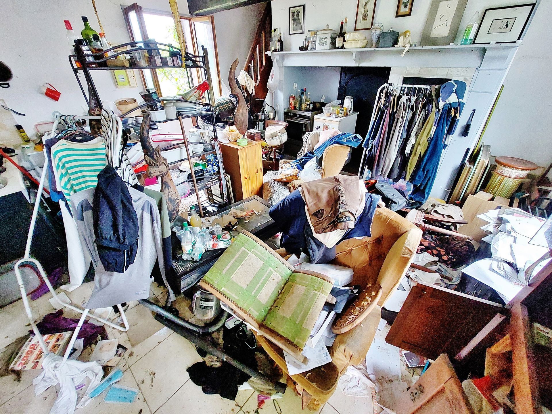 Une pièce de vie avec cheminée remplie d'objets et déchets.