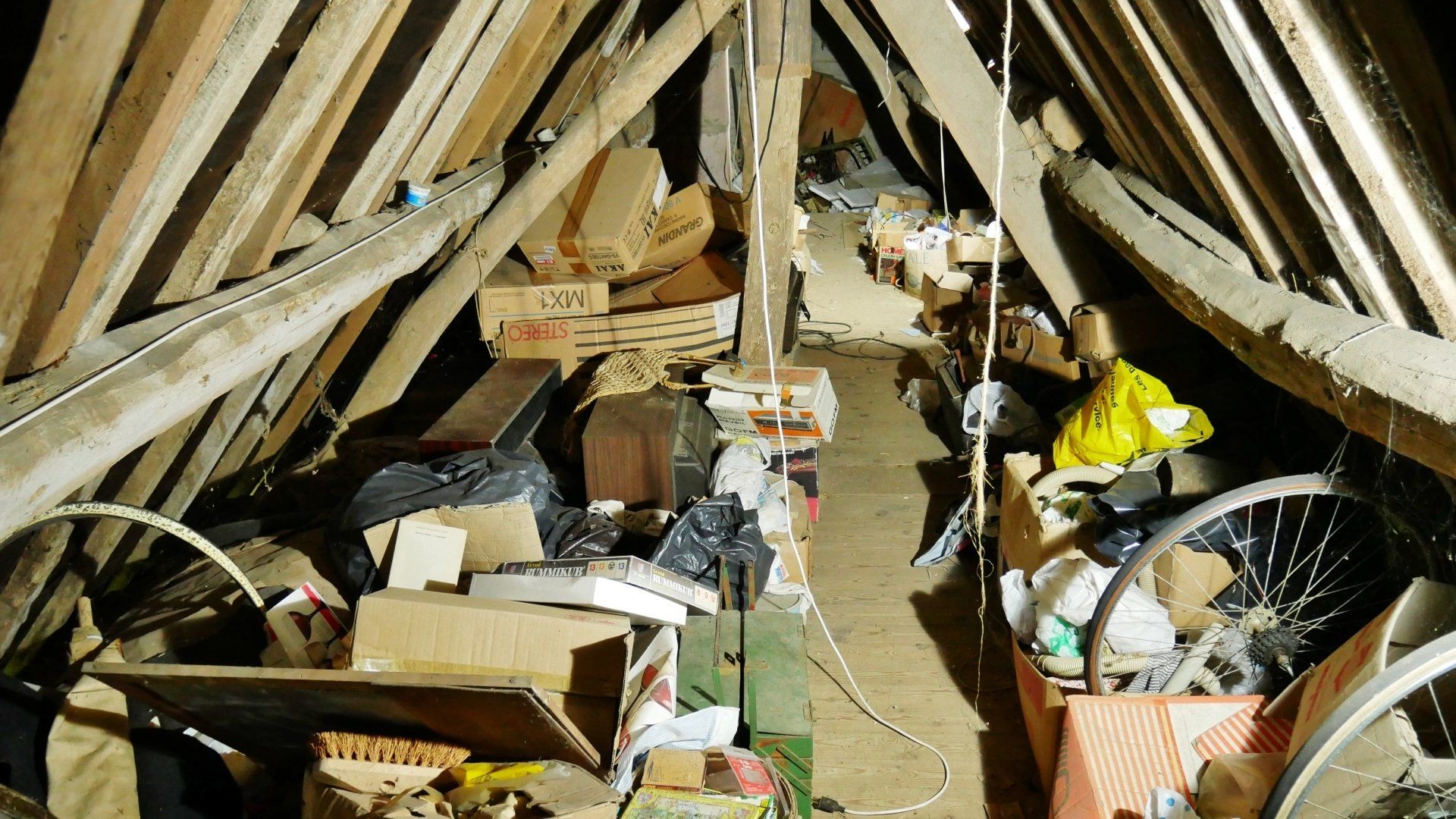 Grenier encombré de cartons et autres déchets.
