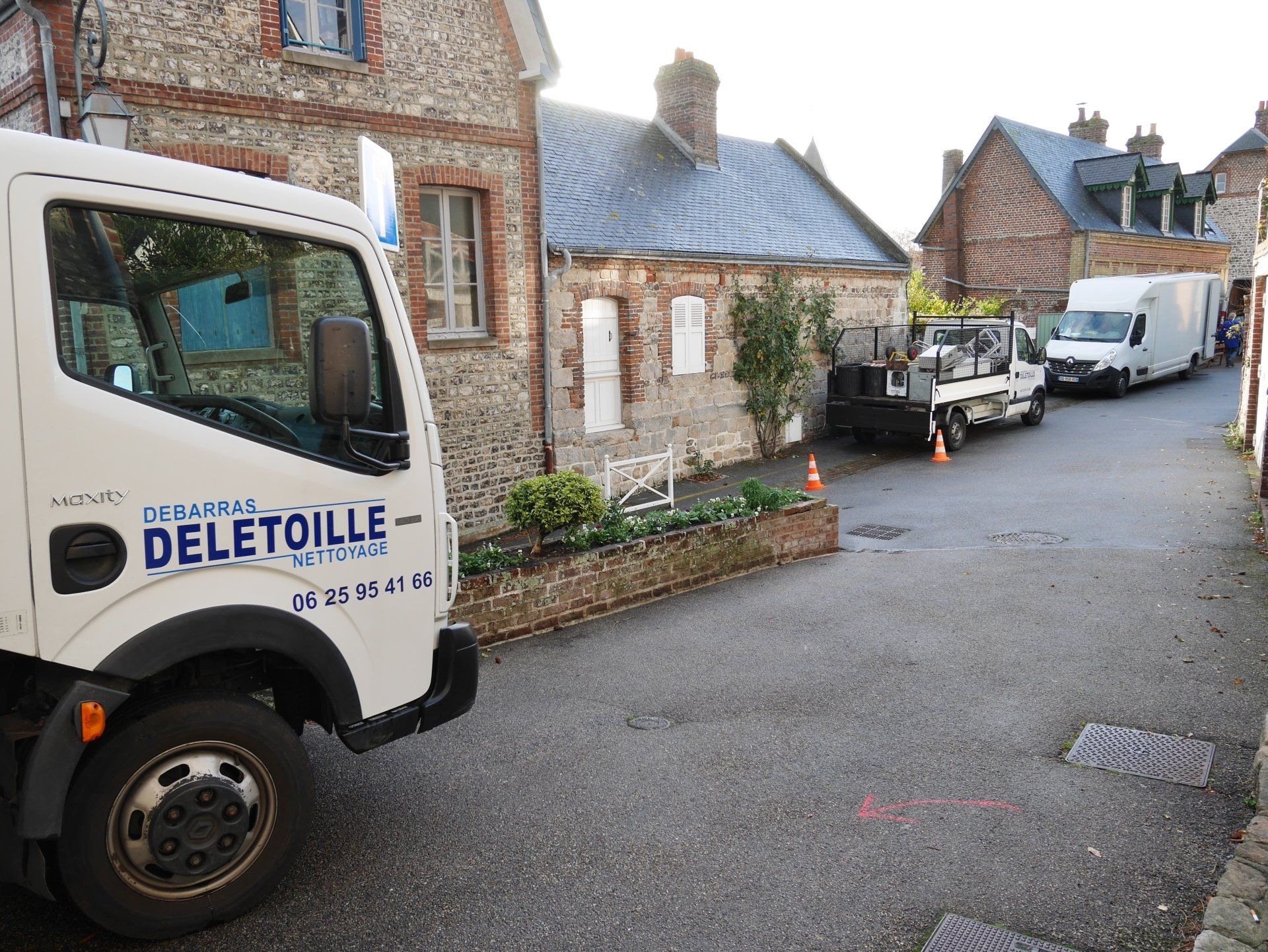 Un camion d'entreprise DELETOILLE Débarras Nettoyage stationné dans la rue.