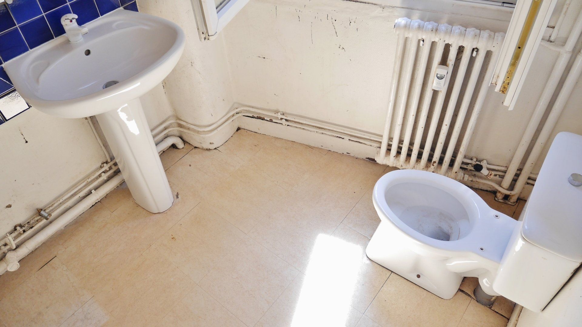 Une petite salle d'eau avec lavabo et WC propre et vide.