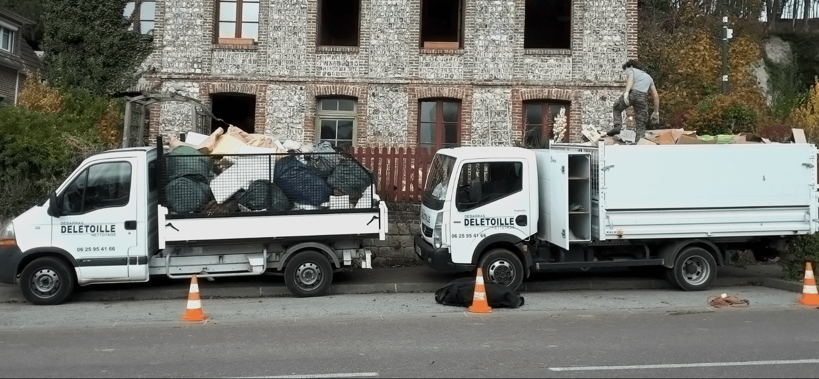 Deux camions garés devant une maison délabrée