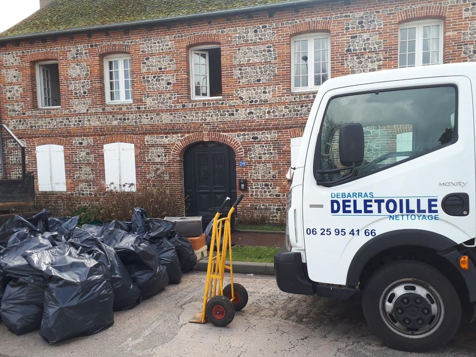 Utilitaire devant une maison en brique avec des sacs poubelles et un diable jaune