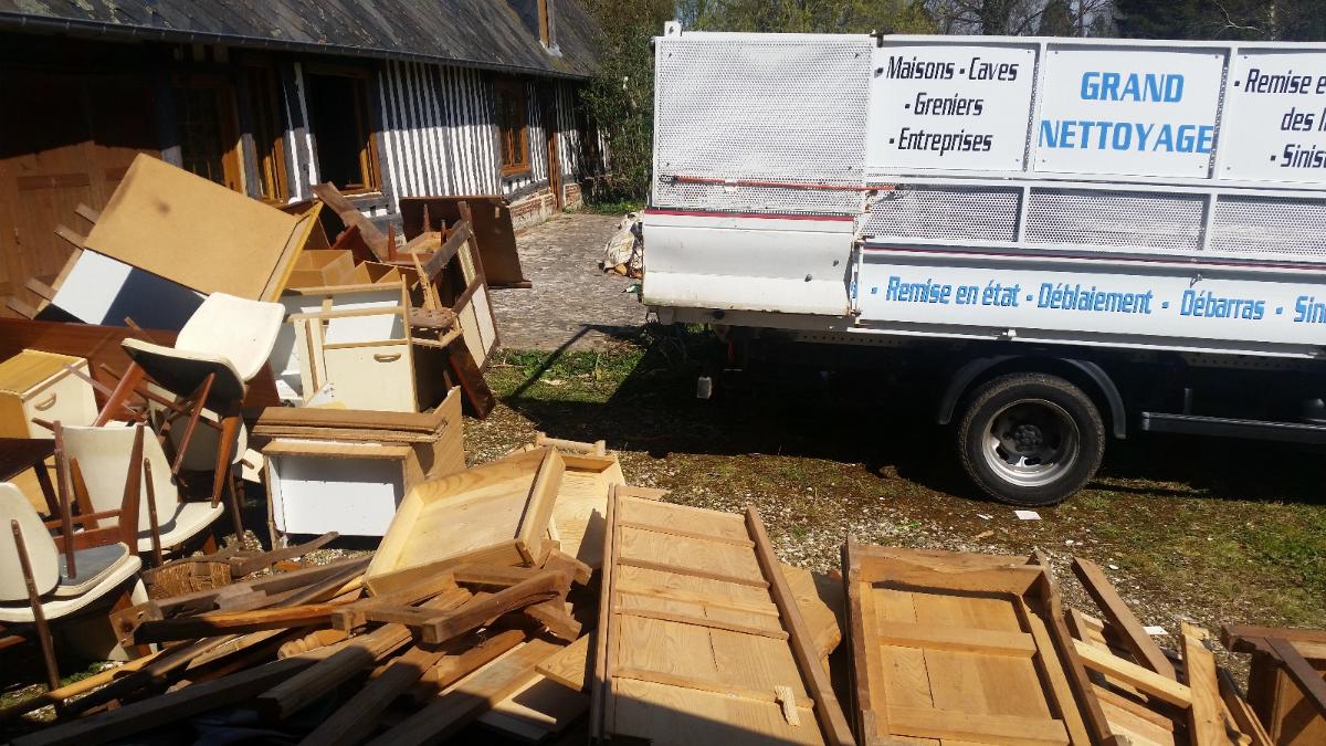 Un tas de mobilier au pied d'un camion-benne.