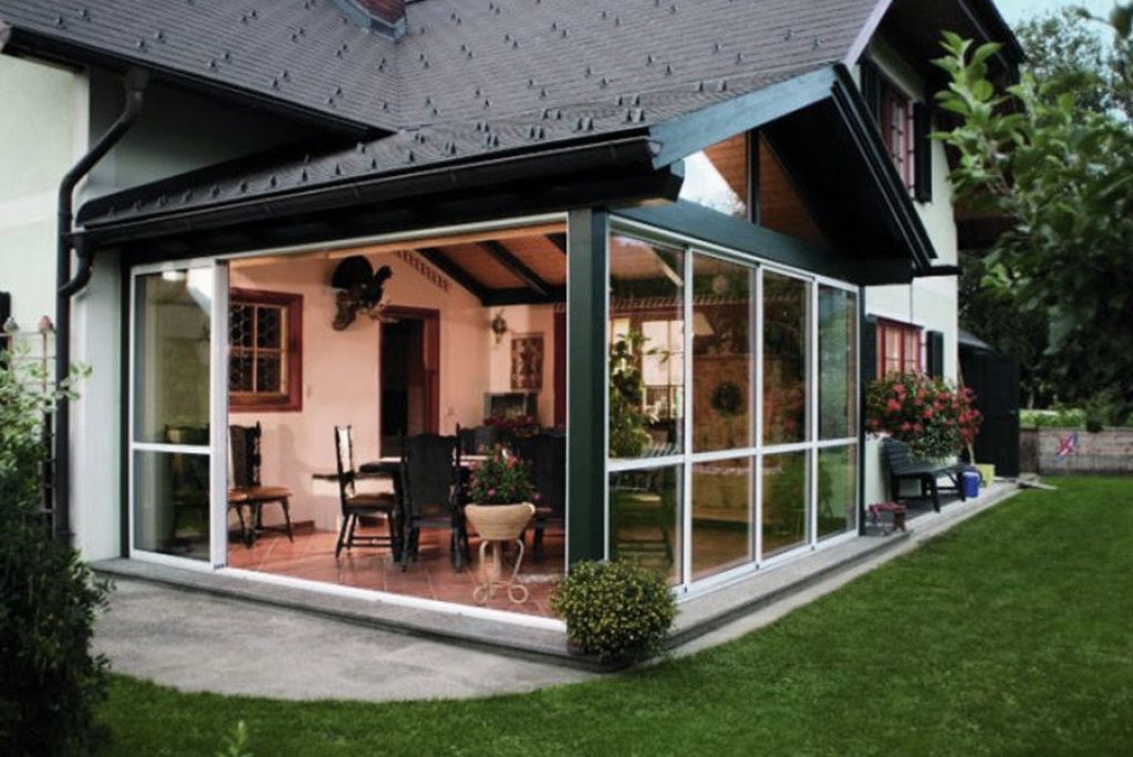 Ein Haus mit einer großen Veranda mit vielen Fenstern