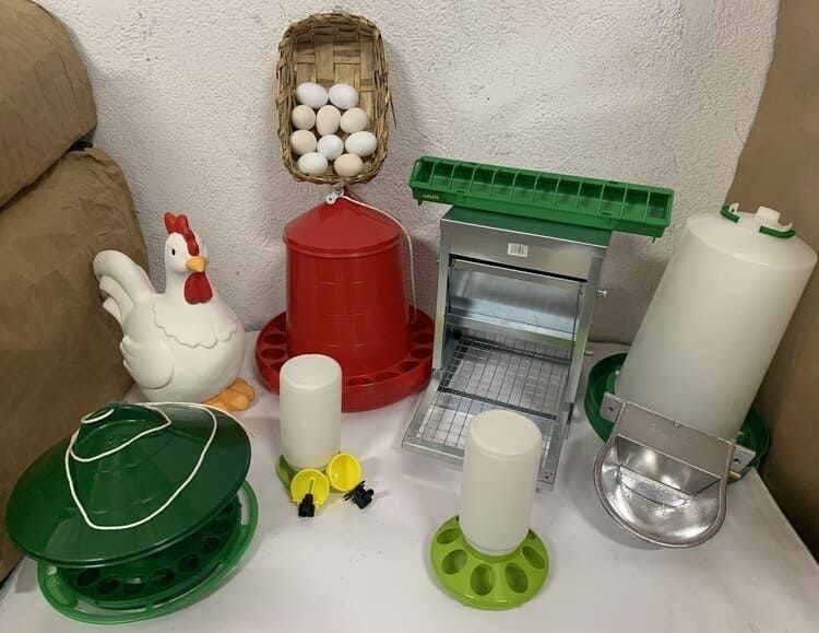 Un montón de suministros para pollos están sobre una mesa.
