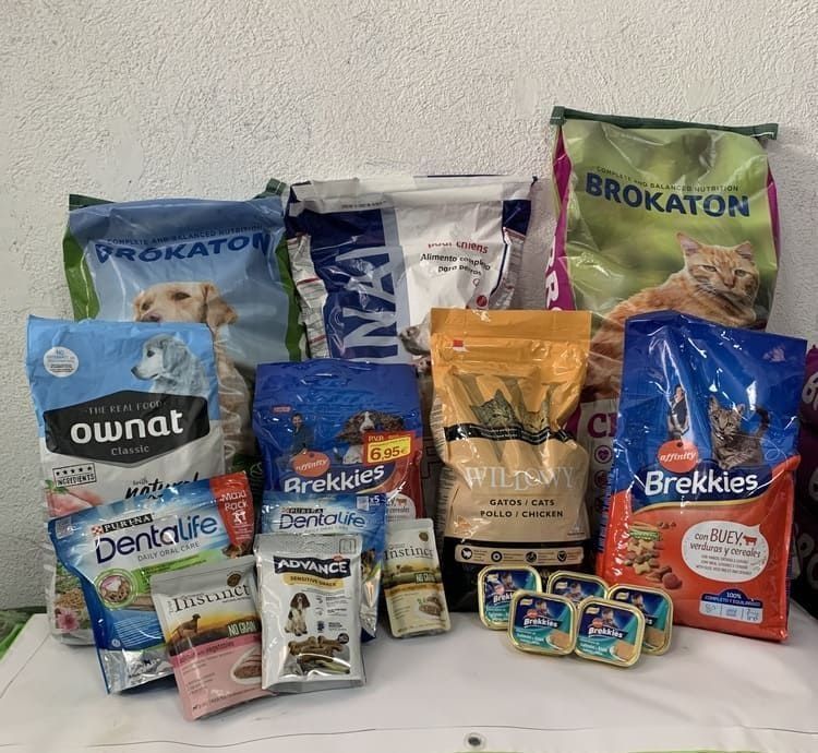 Un montón de bolsas de comida para perros están sobre una mesa.