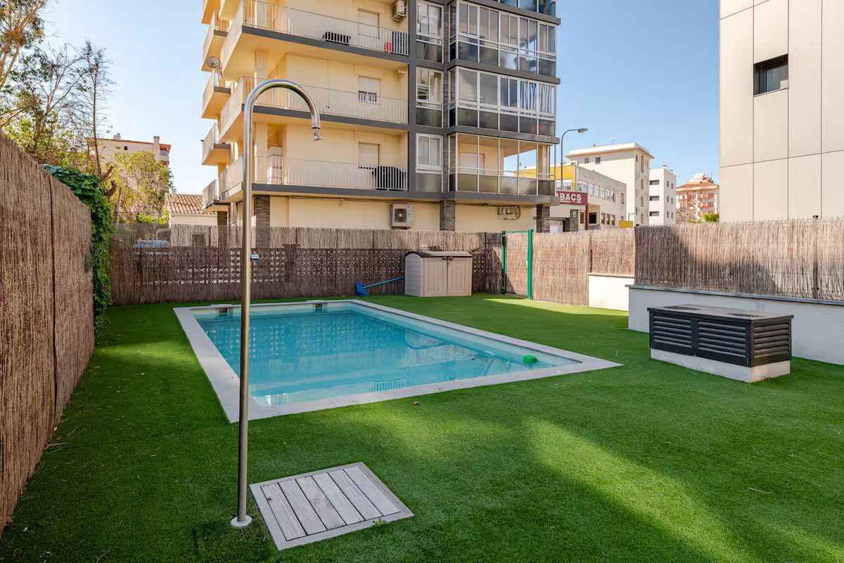 Hay una piscina en el patio trasero de un edificio.