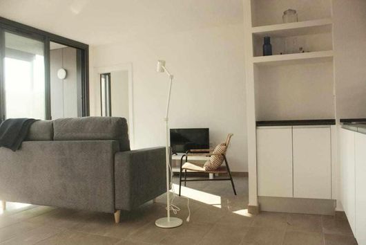 Una sala de estar con un sofá, una silla y un televisor.