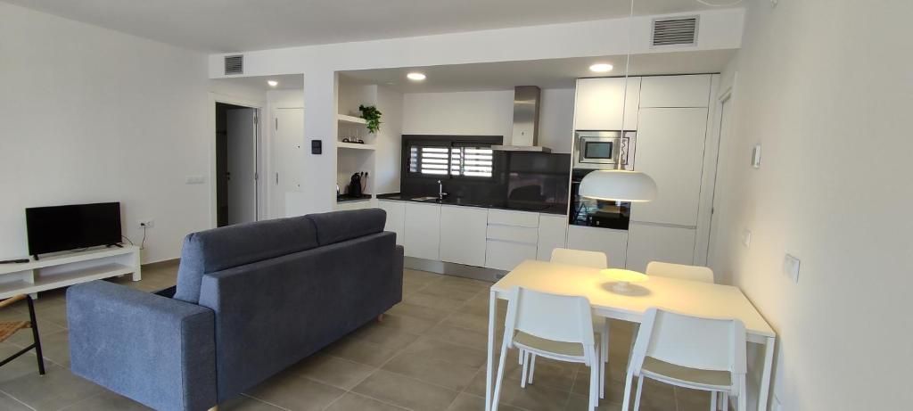 Una sala de estar con sofá, mesa y sillas.