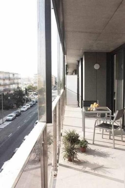 Un balcón con mesa y sillas y vista a una calle.