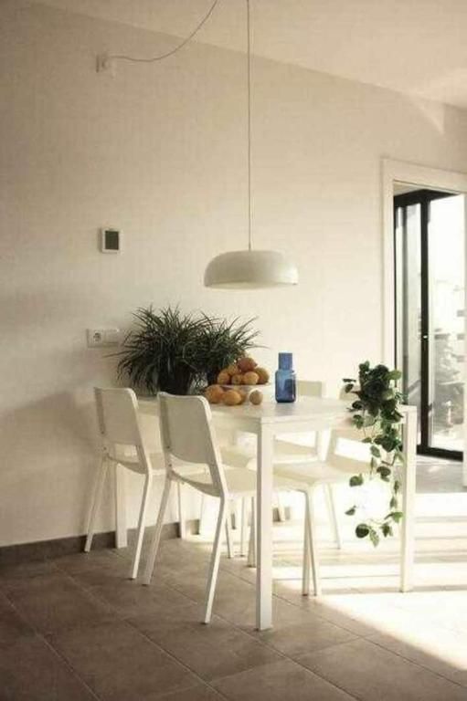 Un comedor con una mesa y sillas y una lámpara colgando del techo.