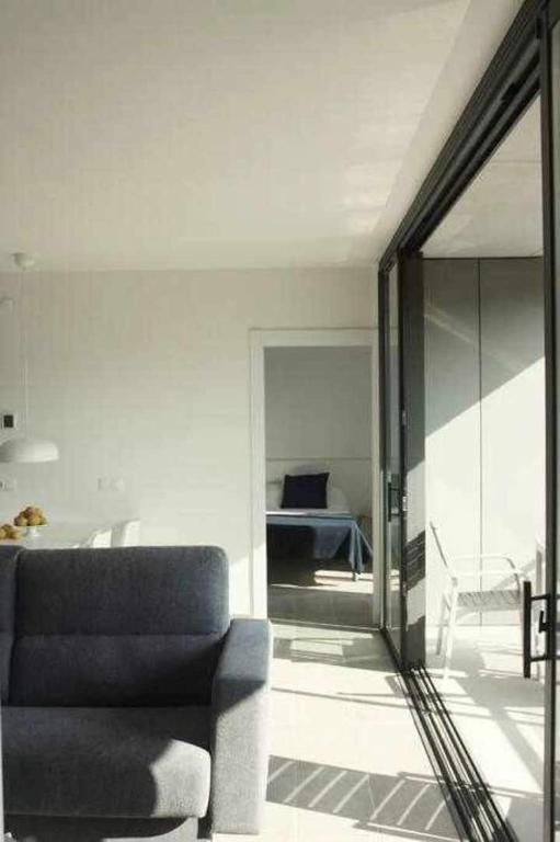 Una sala de estar con un sofá y una silla y una puerta corrediza de vidrio.