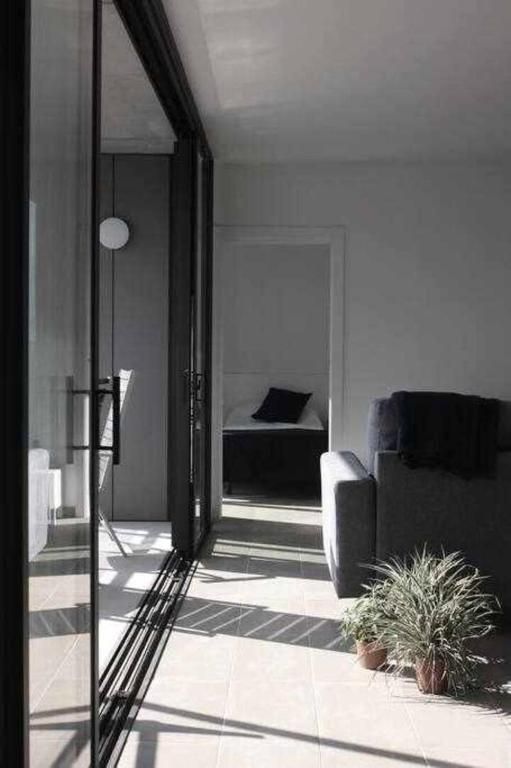 Una sala de estar con un sofá y una cama al fondo.