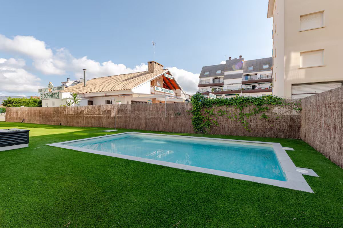 Hay una gran piscina en el patio trasero de una casa.