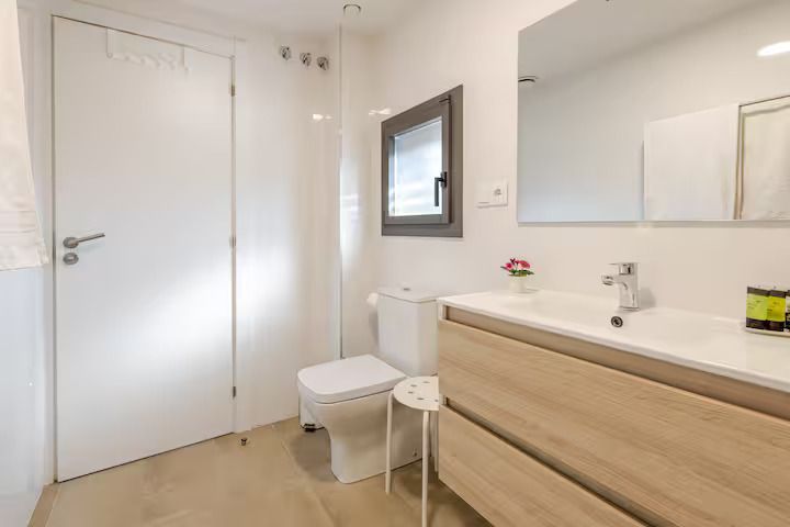 Un baño con inodoro, lavabo y espejo.