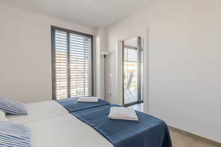 Un dormitorio con dos camas, un espejo y una ventana.