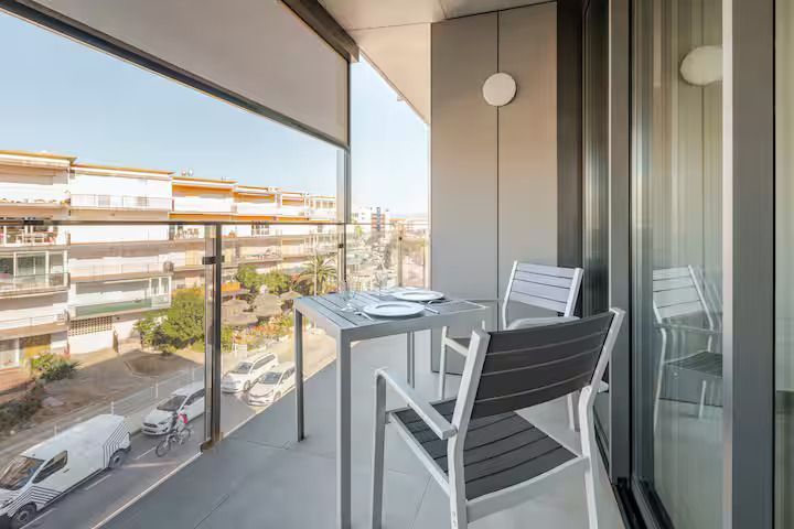 Un balcón con mesa y sillas y vista a la ciudad.